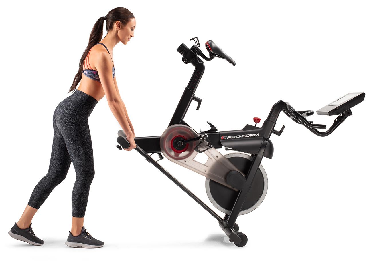 young woman lifting the proform cycle trainer because it's very mobile